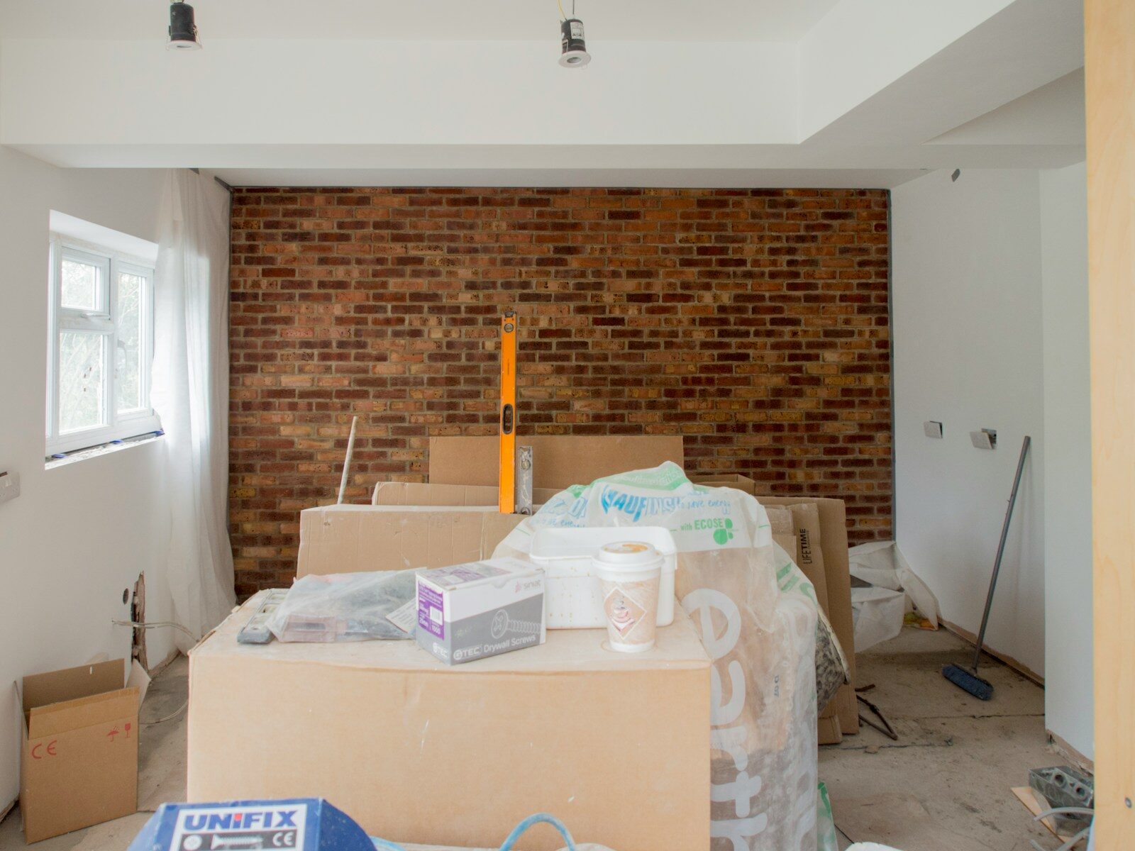A room with a brick wall and boxes on the floor
